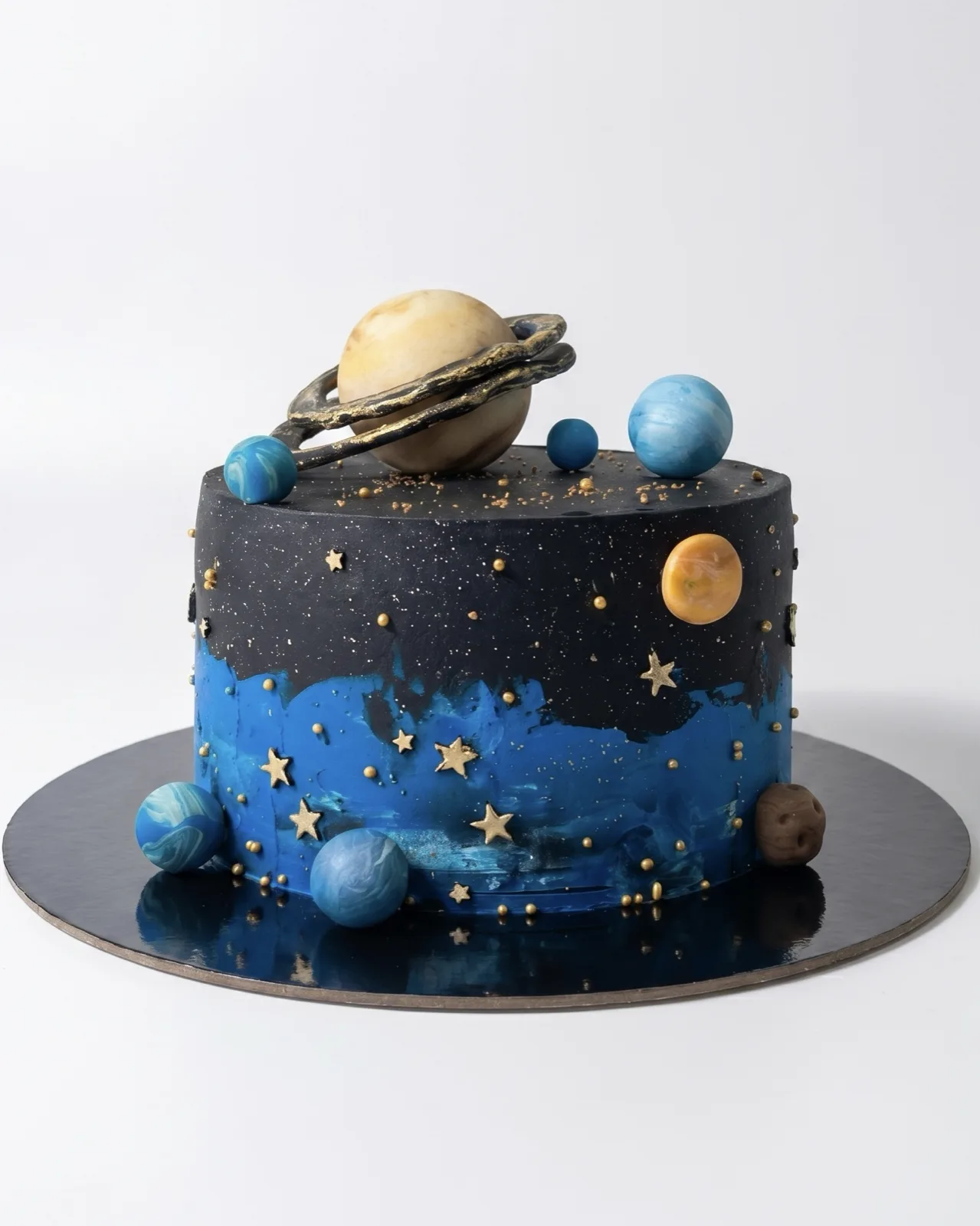 Night-sky galaxy birthday cake with Saturn and hand-shaped planets, a custom cake by Cakes By Vjollca in Pristina, Kosovo