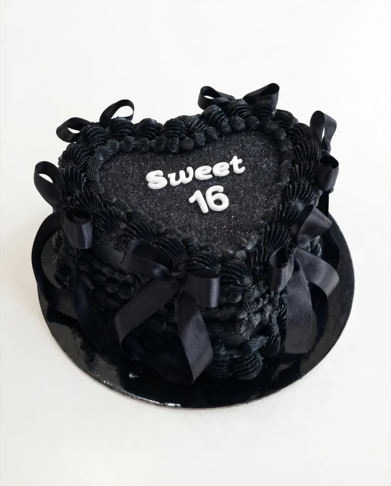 Black vintage heart cake with satin bows for a Sweet 16 birthday, a custom cake by Cakes By Vjollca in Pristina, Kosovo