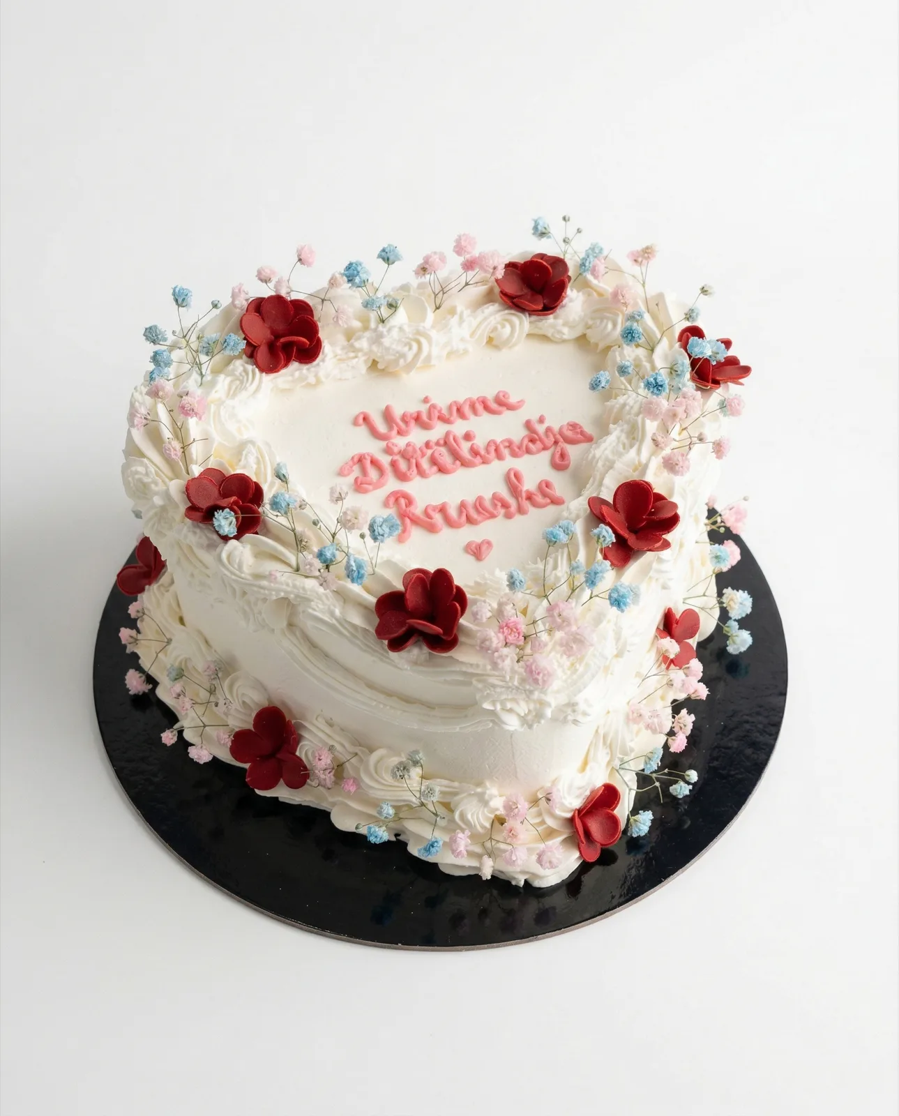 White heart cake with red and pink sugar blossoms and a piped birthday wish, a custom cake by Cakes By Vjollca in Pristina, Kosovo