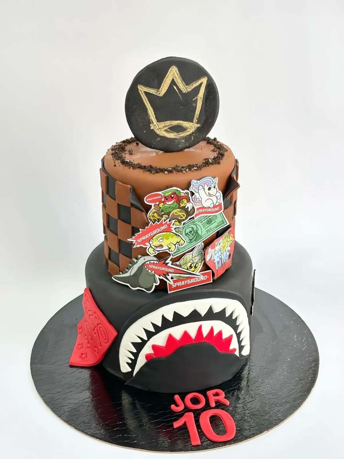 Streetwear-themed 10th birthday cake with checkerboard tiers and sticker art, a custom cake by Cakes By Vjollca in Pristina, Kosovo
