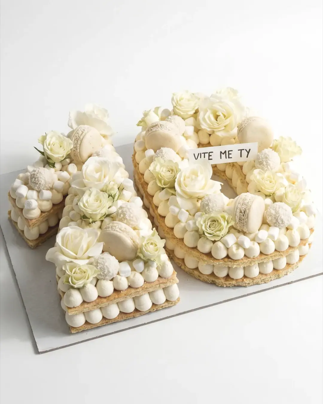 Torte numër dhjetë me trëndafila të bardhë, makarons dhe puçka, torte me porosi nga Cakes By Vjollca në Prishtinë