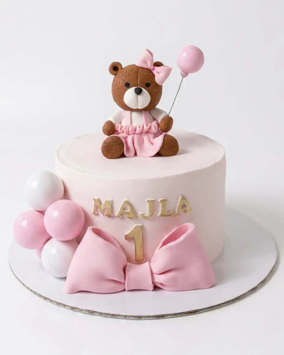 Torte rozë për ditëlindjen e parë me arush, fjongo dhe tullumbace, torte me porosi nga Cakes By Vjollca në Prishtinë