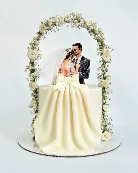 Torte fejese me çift nën hark lulesh të bardha dhe fustan prej fondani, torte me porosi nga Cakes By Vjollca në Prishtinë
